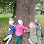 Przedszkolaki przytulają drzewo