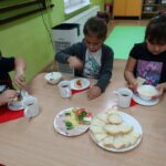 Dzieci przy stolikach spożywają obiad