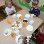 Dzieci przy stolikach spożywają obiad