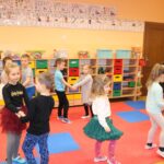 Dzieci tańczą w parach w sali przedszkolnej
