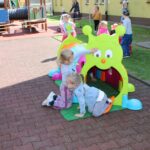 Dzieci bawią się na przedszkolnym placu zabaw, zabawy z wykorzystaniem nowych zabawek terenowych
