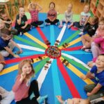 Dzieci bawią się rytmami na kolorowych wstążkach