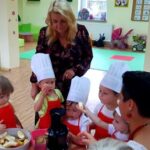 Dzieci z Panią Dyrektor i Panią Magdaleną wyciskają sok owocowo - warzywny