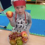 dziewczynka przy misce z owocami