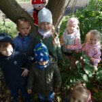 Dzieci stoją pod drzewem na krórym siedzi Hałabała