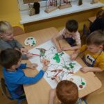 dzieci malują dinozaura farbami