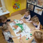 dzieci malują farbami dinozaura