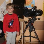 Chłopiec stoi przy telekskopie