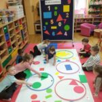 Dzieci segregują figury geometryczne wg koloru.