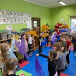Dzieci z grupy Motylki aktywnie słuchają muzyki tańcząc z chustkami