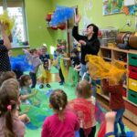 Dzieci z grupy Żuczki podrzucają kolorowe chustki w rytm muzyki