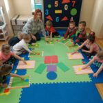 Dzieci z kolorowych figur geometrycznych układają pajaca wg wzoru.