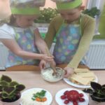 Dzieci wykonuja masło z ziołami.
