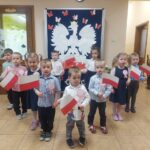 Dzieci z oddziału Mrówki stoją z flagami