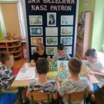 Chłopcy oglądają ilustracje w książkach Jana Brzechwy