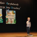 Dziecko recytuje wiersz na scenie