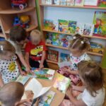dzieci z grupy Żuczki ogladają książeczki