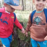 Chłopcy dotykają mech leśny