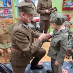 Żołnierz zakłada chłopcu opaskę