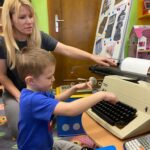 Chłopiec pisze na maszynie do pisania