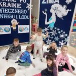 Radosne dzieci tarzają się w sztucznym sniegu