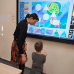 Dziecko układa puzzle na tablicy interaktywnej