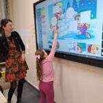 Dziecko układa puzzle na tablicy interaktywnej