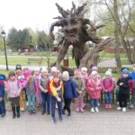 Dzieci przy figurze z drewna