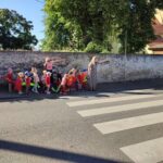 Dzieci przechodzą z nauczycielką przez przejście dla pieszych