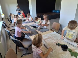 dzieci wykonują liście