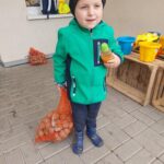 Chłopiec niesie worek ziemniaków na koniec dnia w przedszkolu