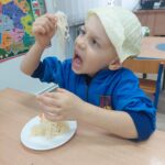 Chłopiec z apetytem zajada kiszoną kapustę