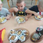 Dzieci jedzą przygotowane przez siebie ziemniaczki z sekiem