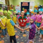 Dzieci przebrane za owoce tańczą w kółeczku