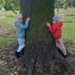 Dzieci przytulają się do drzewa 2