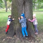 Dzieci przytulają się do drzewa 3
