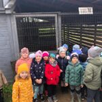 Dzieci stoją przed kurnikiem