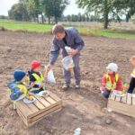 Pan Dariusz czestuje dzieci sokiem marchewkowym