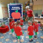 dzieci tańcżą i śpiewają piosenkę Małe czerwone jabłuszo