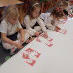 Dziewczynki układają puzzle godło Polski