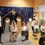 Przedszkolaki z symbolami bożonarodzeniowymi recytują wiersz