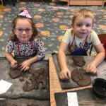 Dzieci rysują wzory na glinie