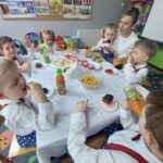 Dzieci-siedzą-po-występie-przy-stoliku-i-zajadaja-babeczki