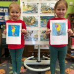 Dziewczynki prezentują kartę pracy z Syrenką Warszawską