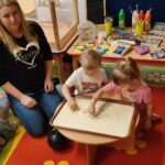 Tymon z Zosia maluja obrazek na kaszy