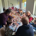 dzieci z seniorami ozdabiają pisanki