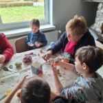 dzieci z seniorami ozdabiają pisanki