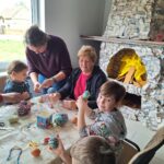 dzieci z seniorami ozdabiają pisanki