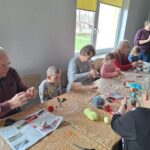 dzieci z seniorami ozdabiają pisanki