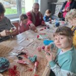 dzieci z seniorami ozdabiają pisanki